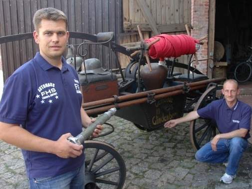 Ortswehrleiter Andy Opitz (links) und Lars Haubitz präsentieren die Handdruckspritze, die seit 1905 in Besitz der Glindenberger Wehr ist. Foto: Karl-Heinz Klappoth